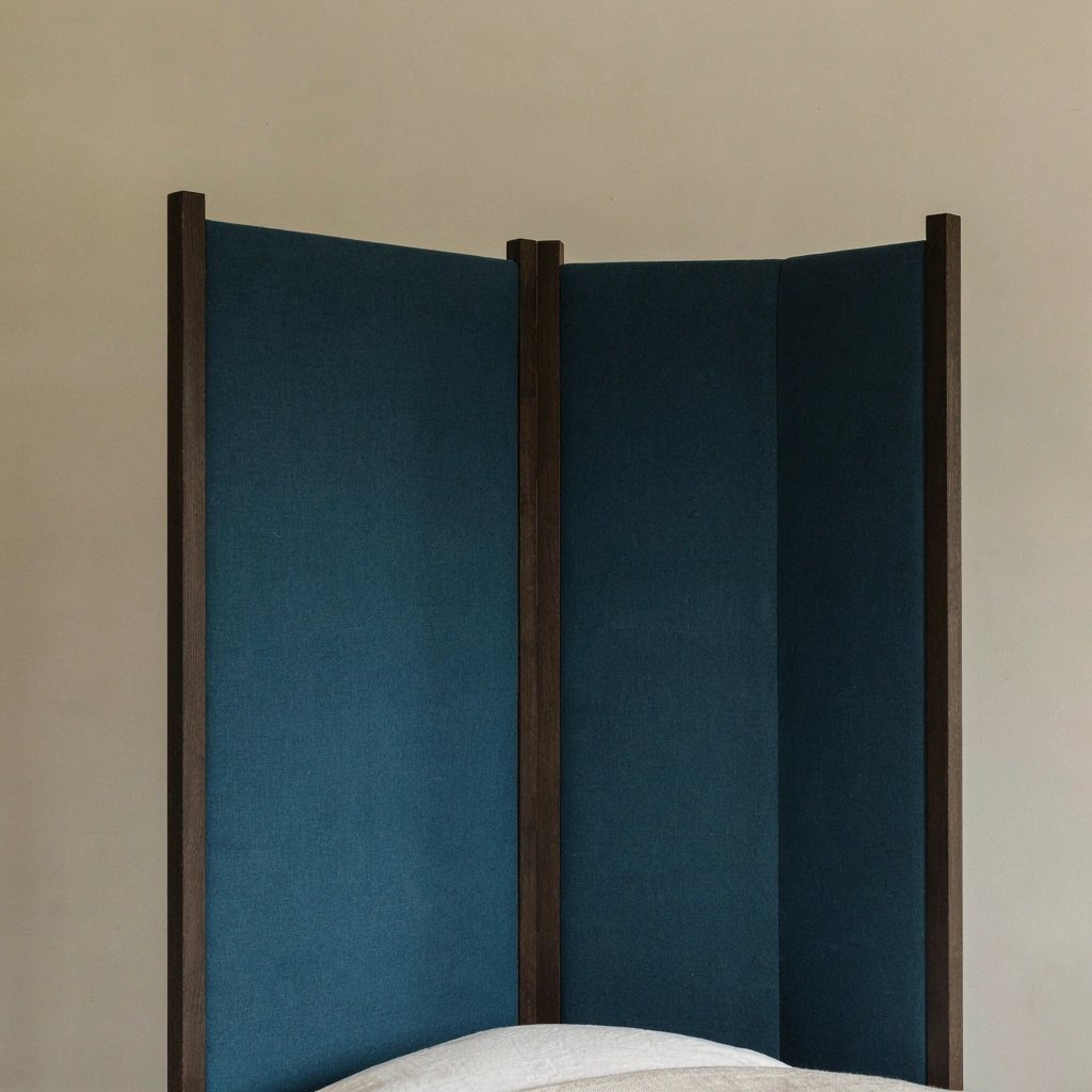 Voiles bleu canard sur un lit à baldaquin en bois sombre